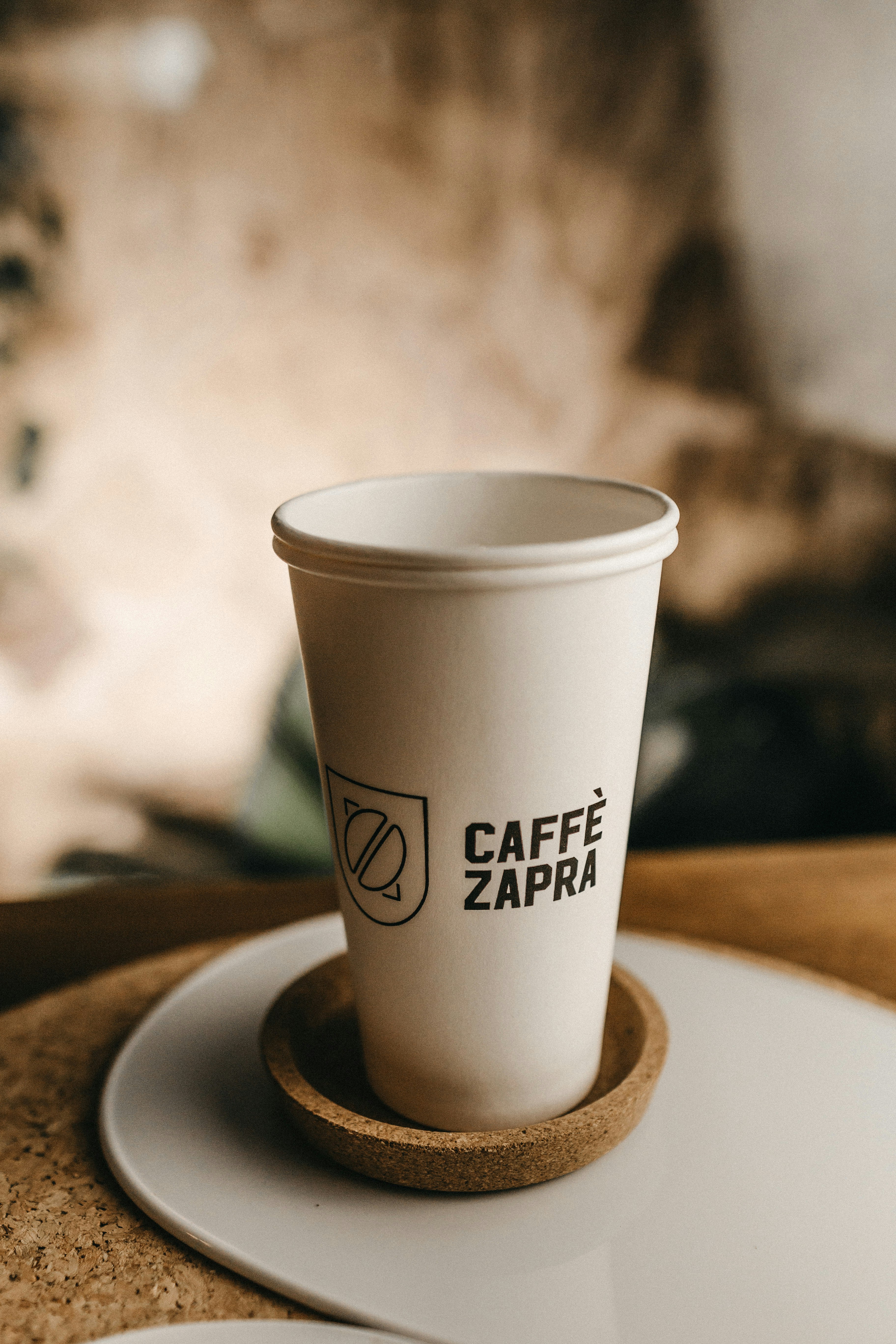 white and black Caffe Zapra cup on table